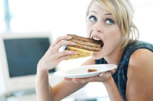 Close-up of a woman eating a large piece of cake